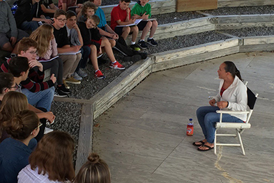 Photo of students gathered around a person telling a story.