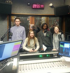 Photo of four students in a radio booth.