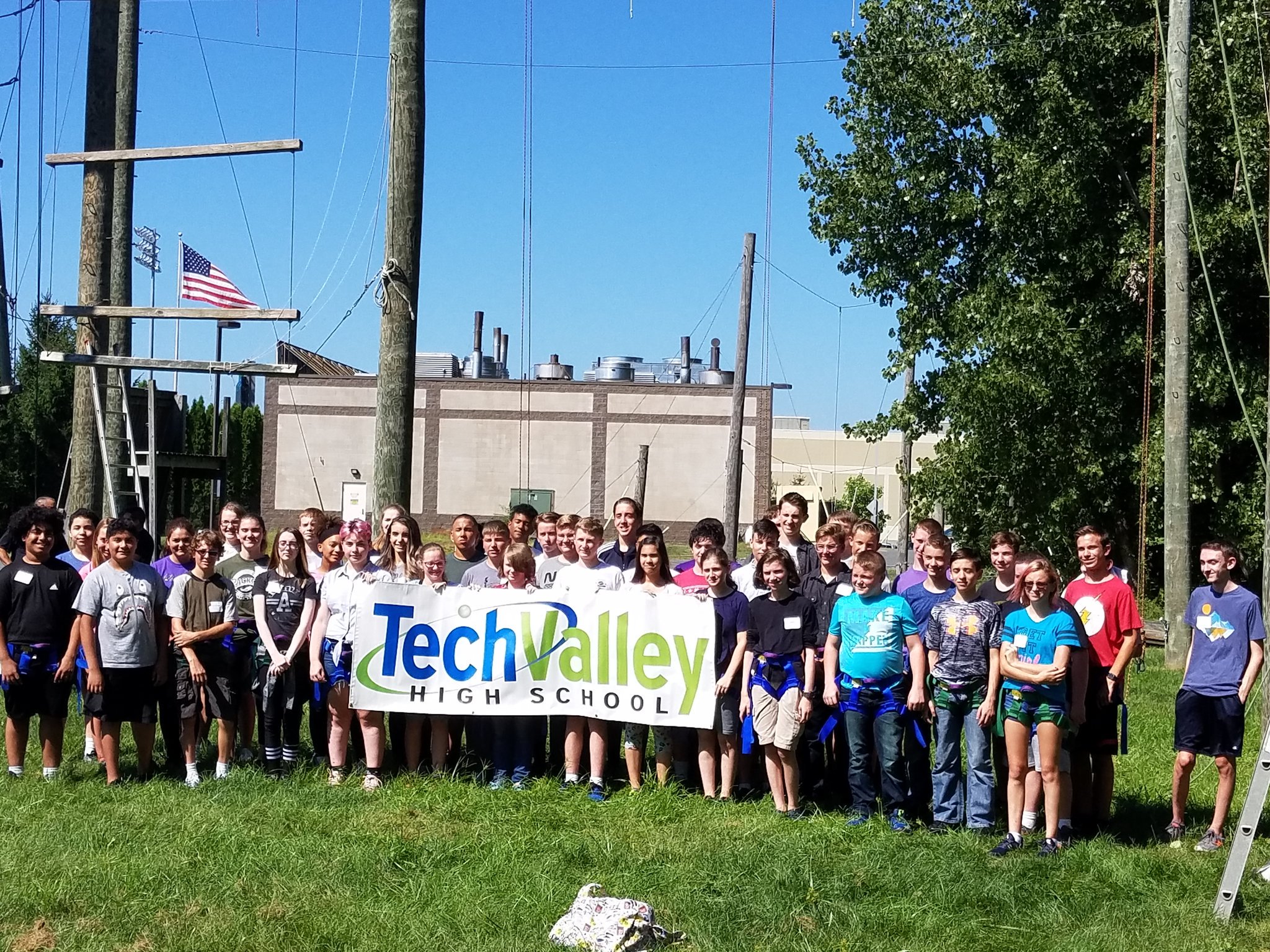 Photo of TVHS students holding banner in front of a ropes couse