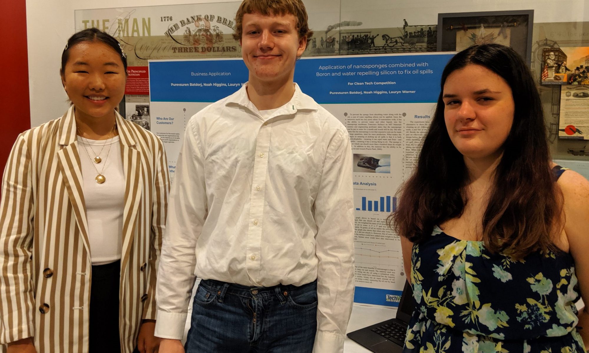 Photo of three students in front of a display board